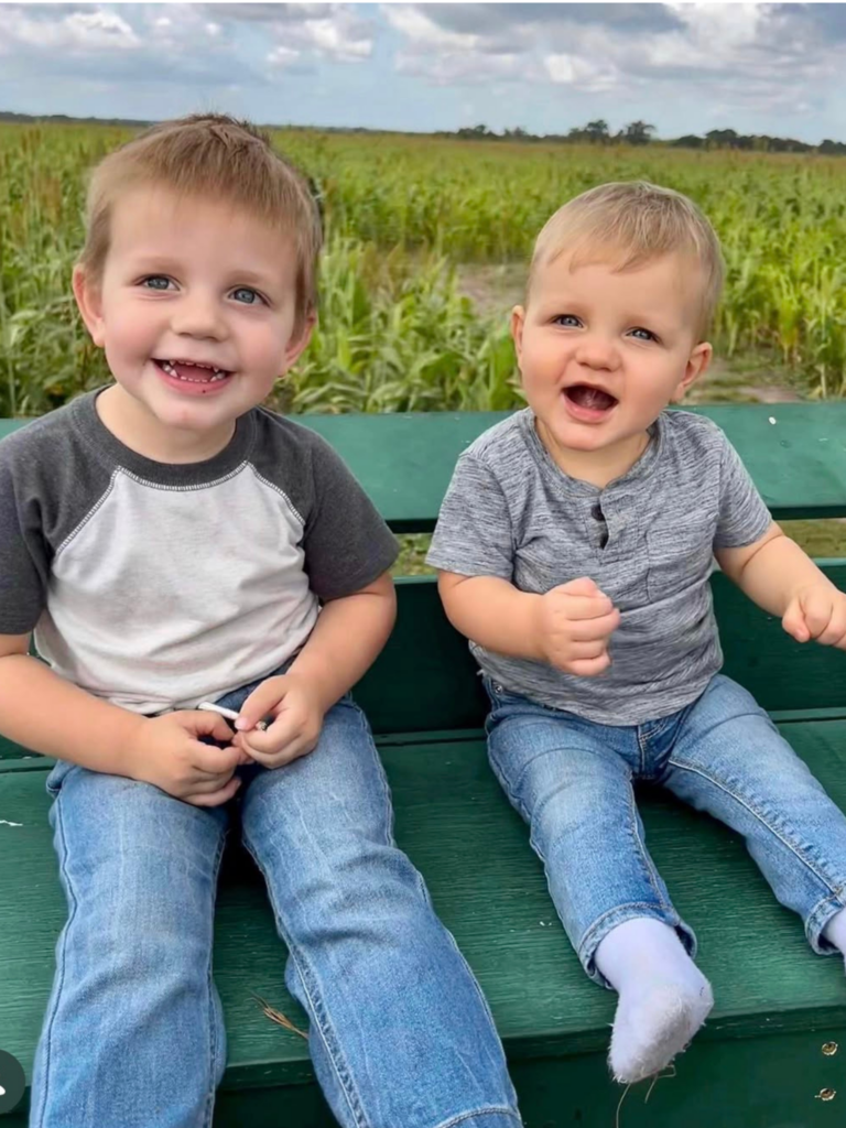 Two young boys smiling and having fun on a tractor hayride at Dade City Farms in Florida